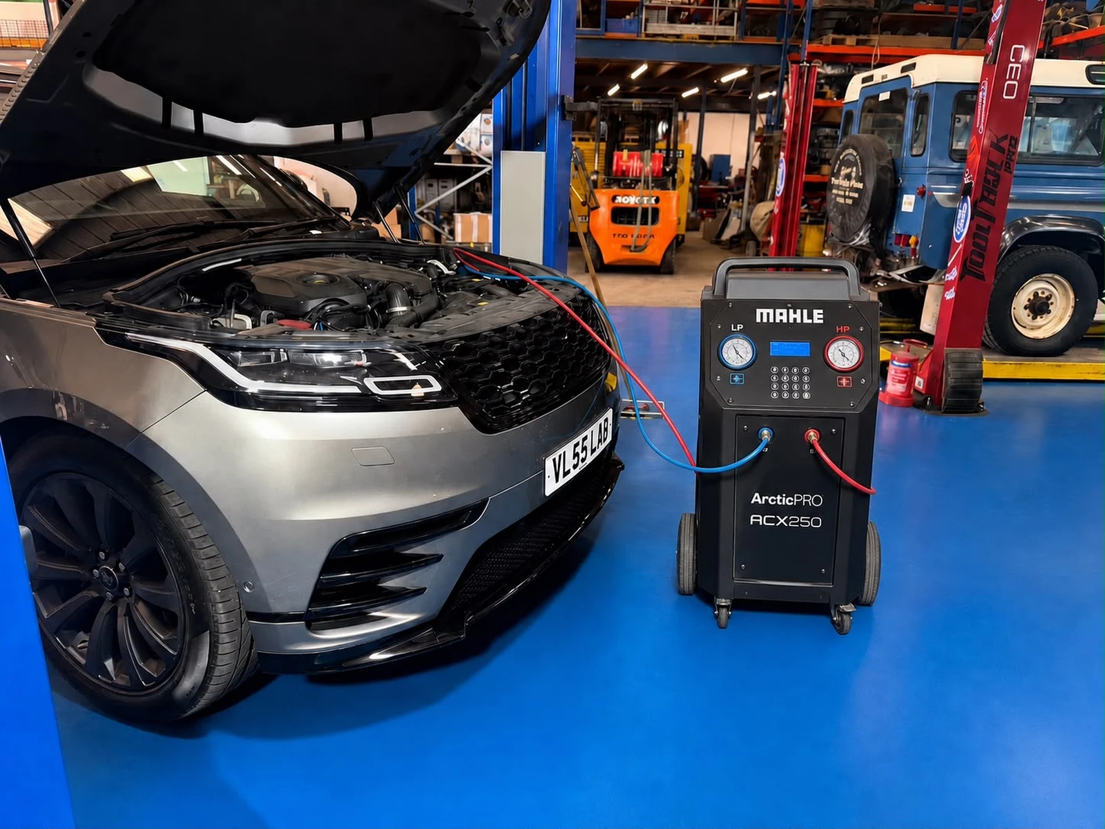 Silver Range Rover connected to AJ 4X4 air-conditioning re-gas equipment in the workshop