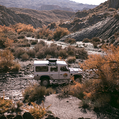 Land Rover Defender navigating rugged terrain serviced by AJ 4X4 