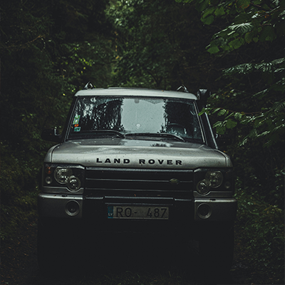 Land Rover Discovery navigating through a dense forest serviced by AJ 4X4 